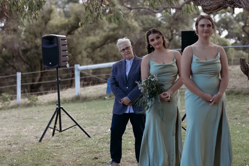 Lizanne standing with two bridesmaids in sage green dresses