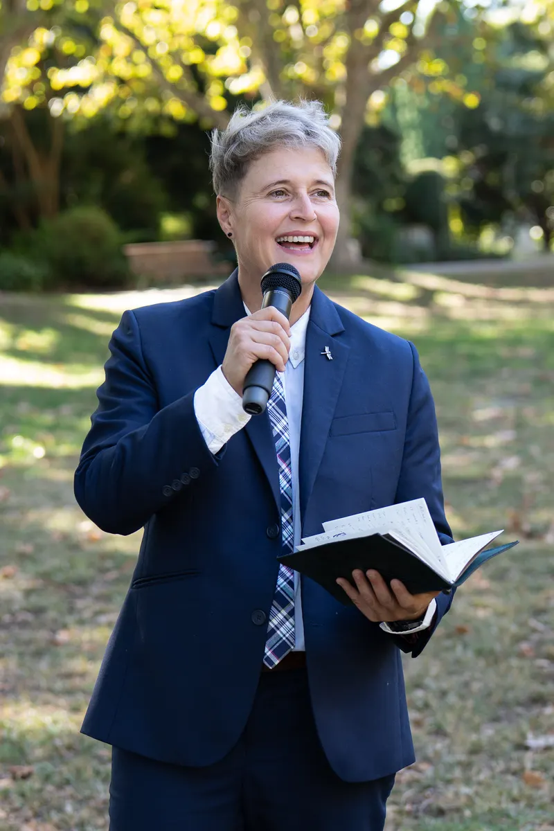 Lizanne laughing into a microphone with her script in hand